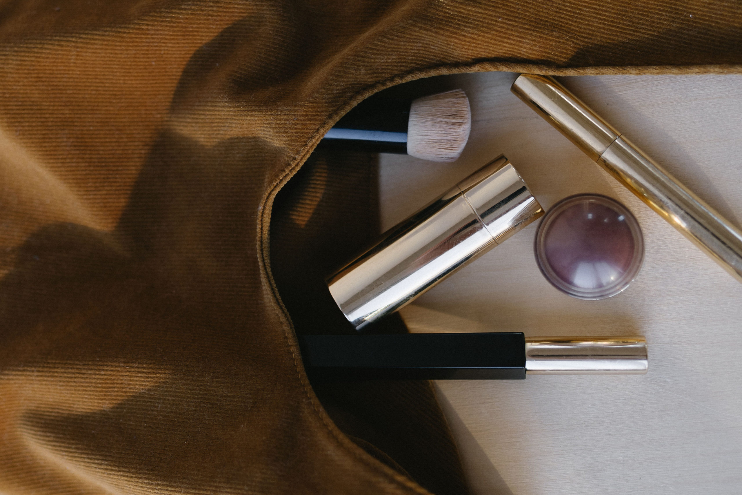 Luxury beauty products spilling from a cosmetics bag representing beauty and wellness marketing presence for small business owners