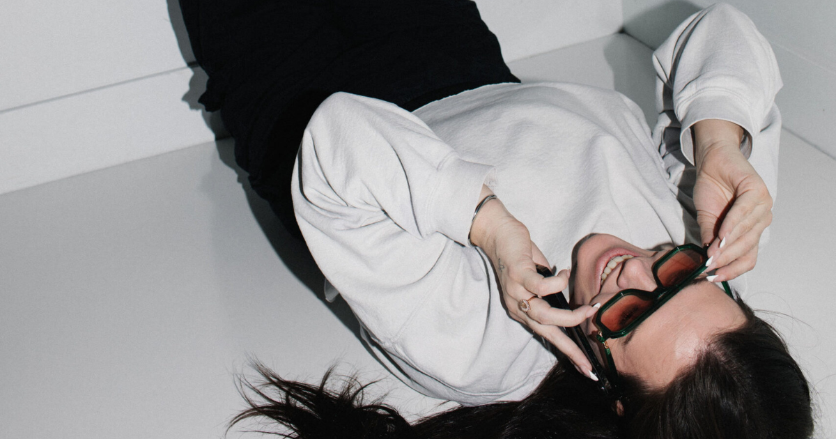 Woman lying upside down laughing representing small business owner reaction to AI content watermarking panic
