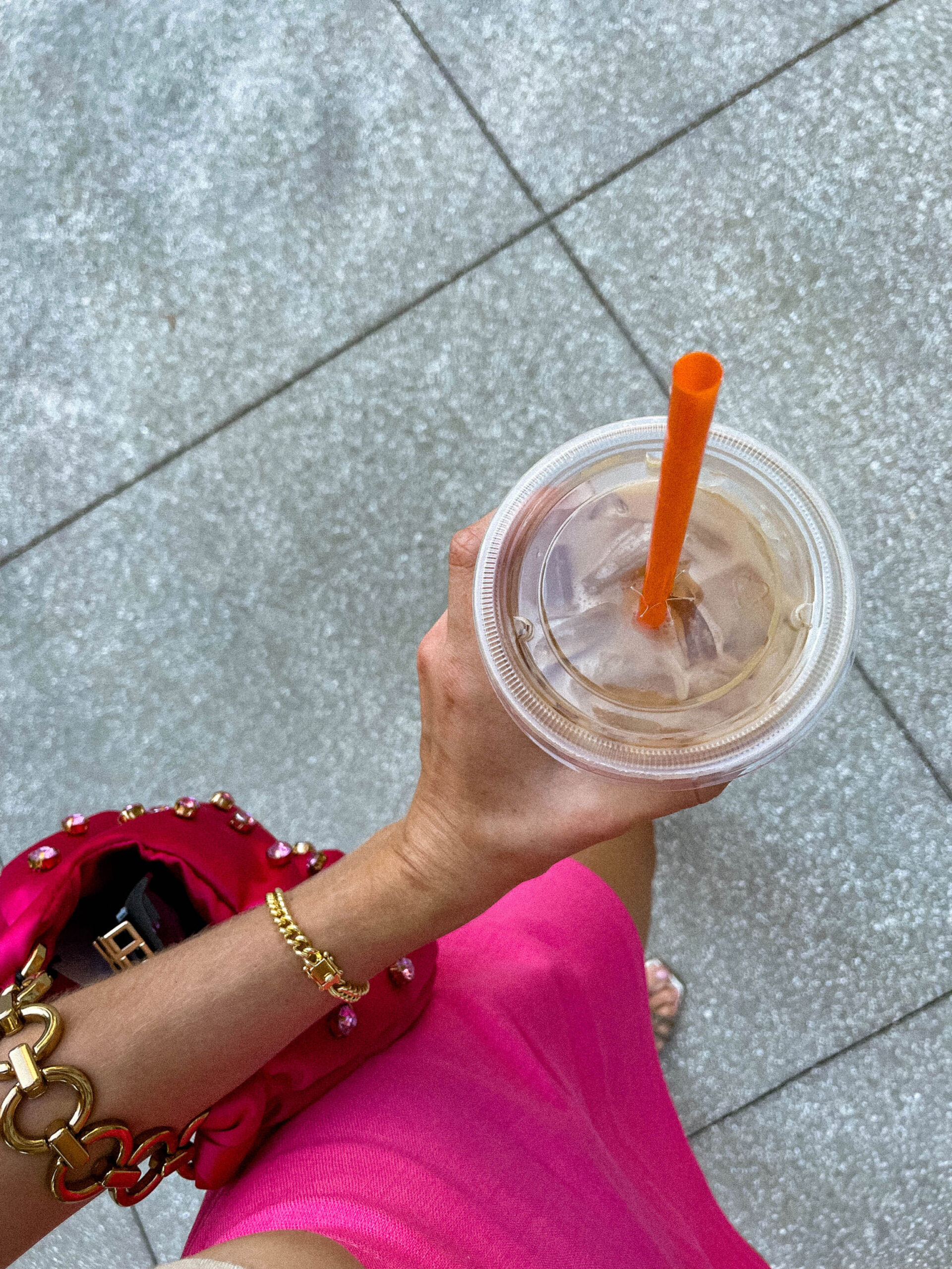 marketing strategist with iced coffee and pink bag planning marketing budget